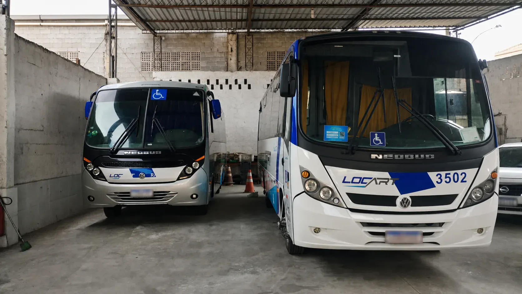 Dois veículos Locart estacionados no pátio coberto da empresa